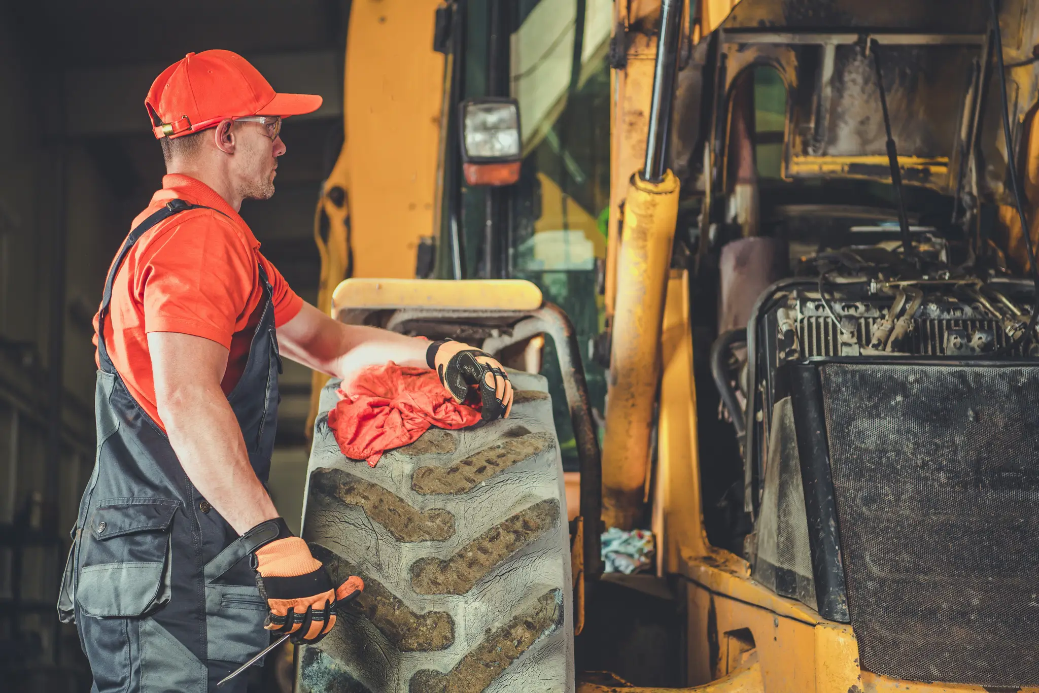 Man Working On Tractor and Replacing Tire